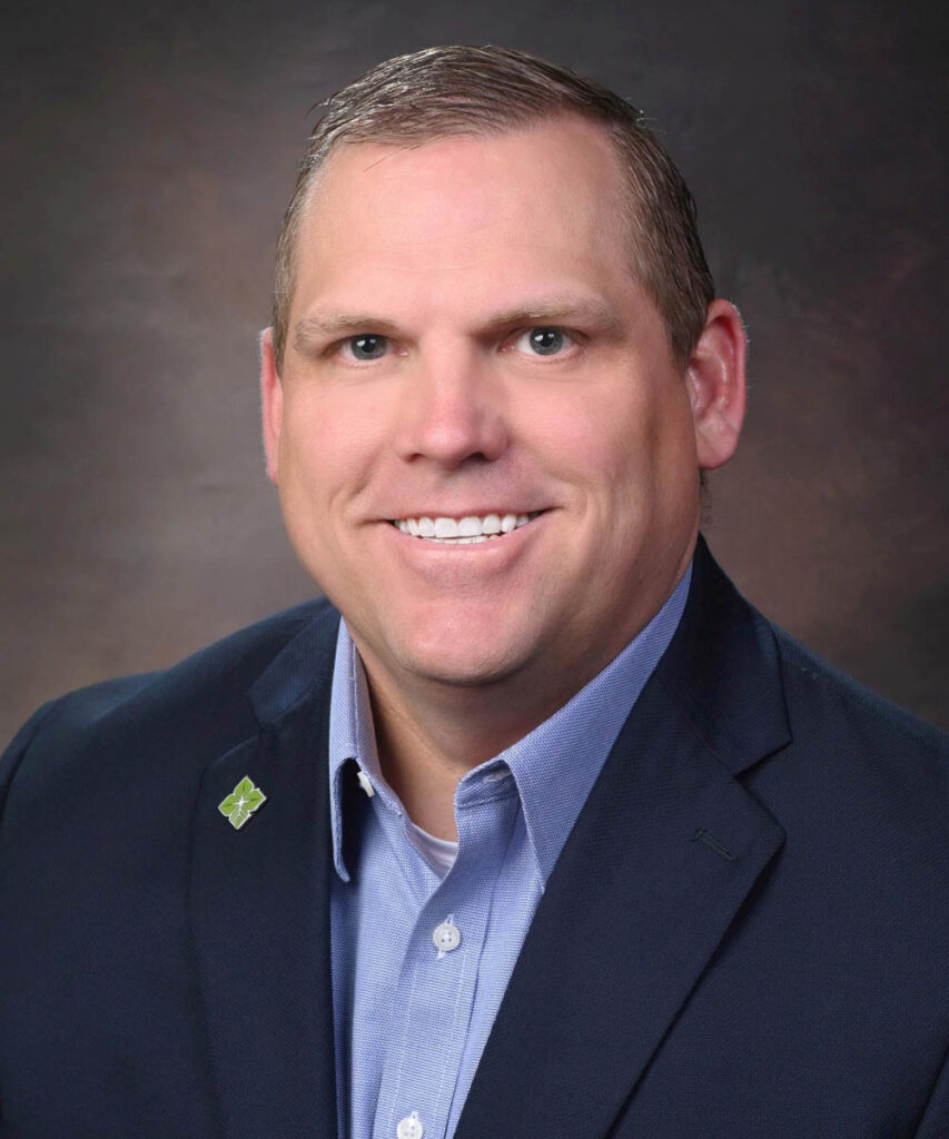 professional head-shot of Evan Bingham wearing a blue sports coat over a light blue shirt. He has a green biostar pin on his lapel.