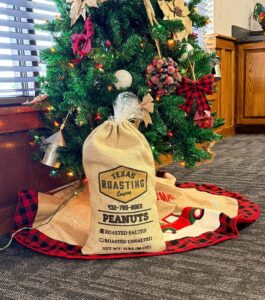 Big bag of peanuts sitting in front of a Christmas tree